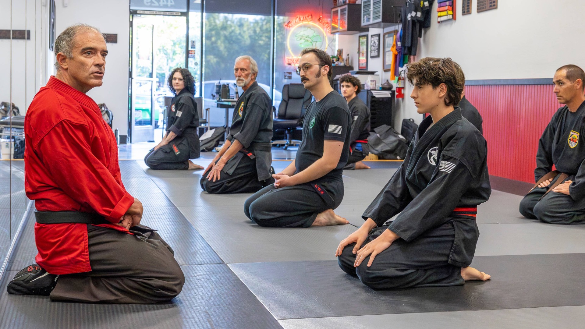 Chief Instructor Michael Delfino sits in front of an Adults Karate Class as they begin meditation