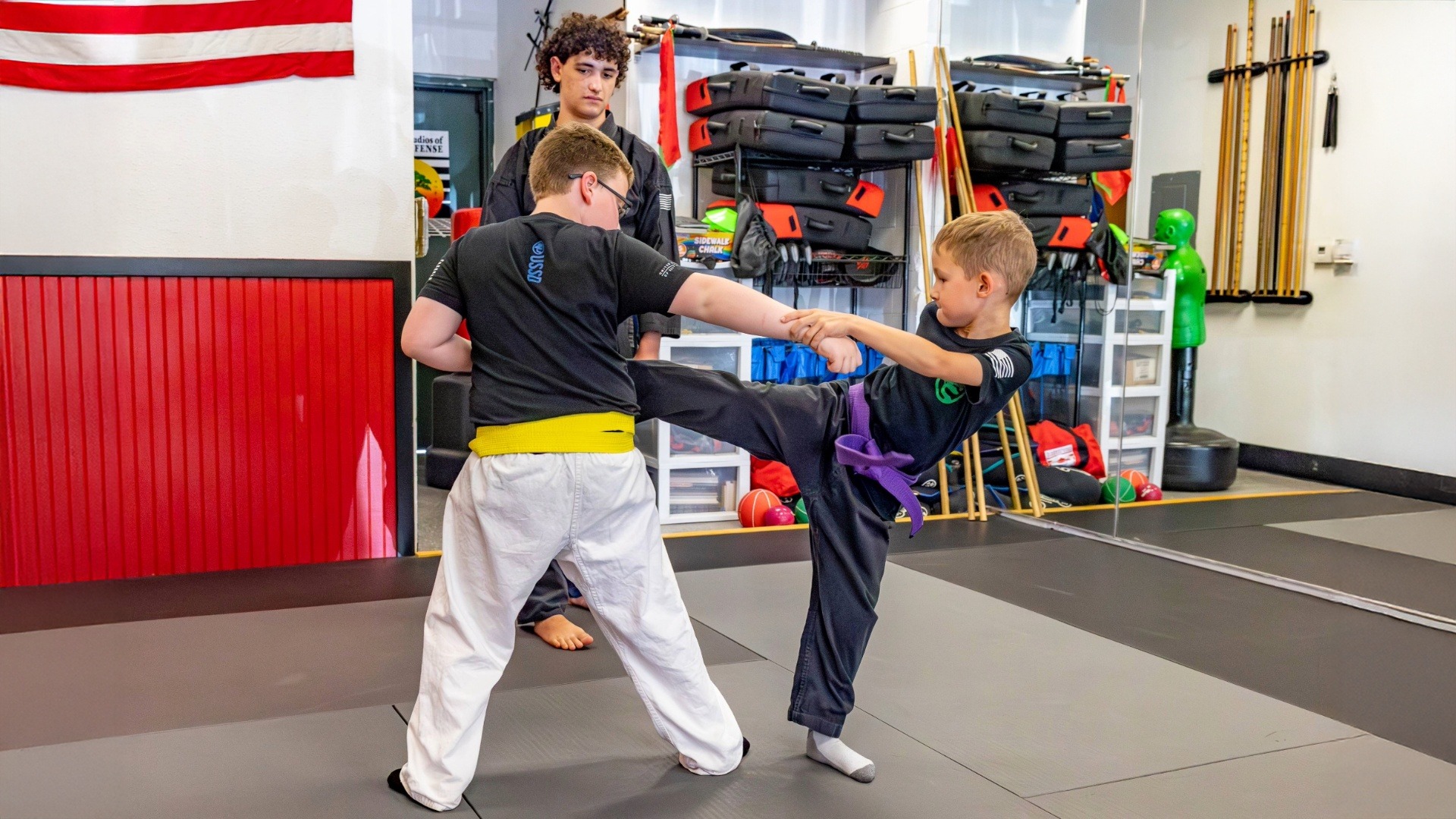 Two young USSD karate students are practicing their kicks in class.