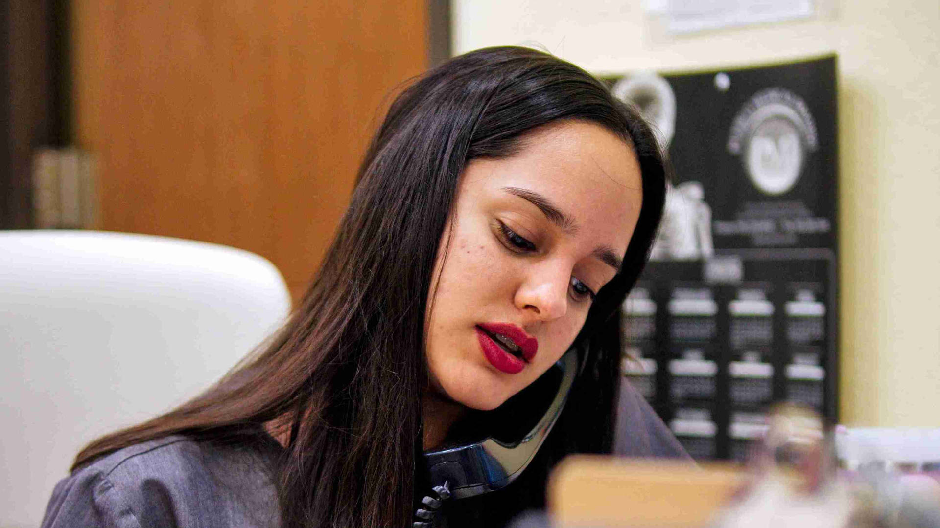Front desk receptionist from Clinica Mi Pueblo attending a call from a client on the phone