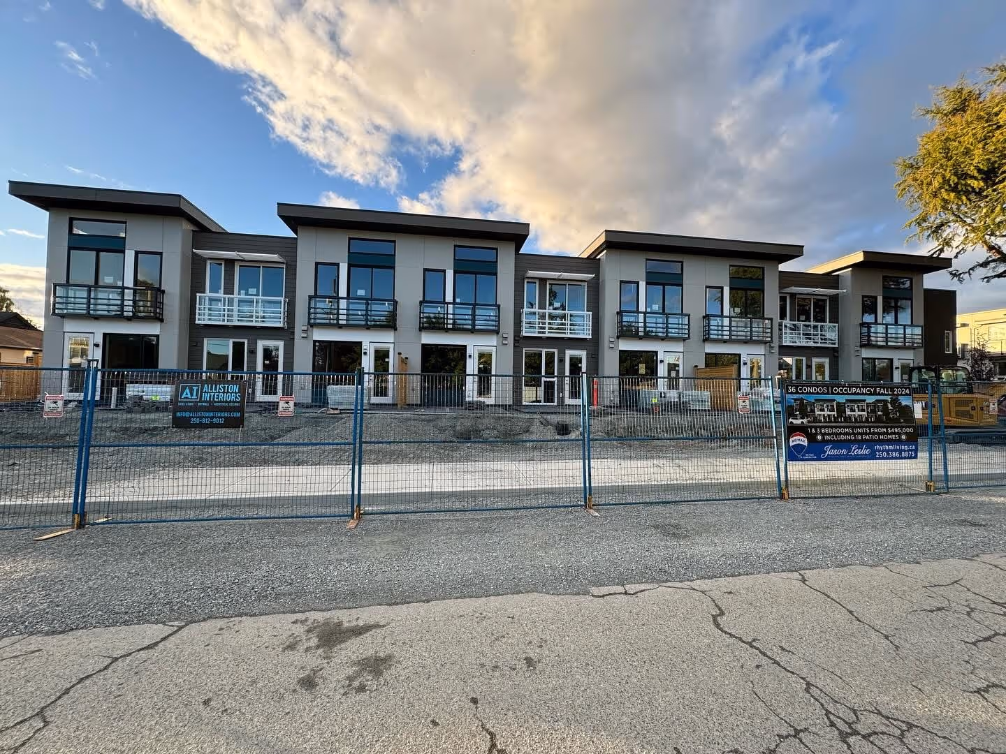 Newly built row of modern townhomes with balconies and large windows.