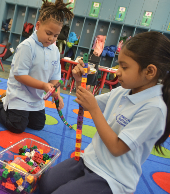 Dos niñas con su uniforme escolar sonriendo a la cámara  