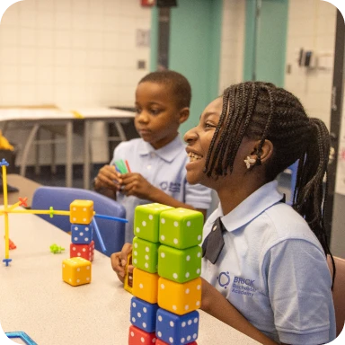 Two students playing with building block toys 