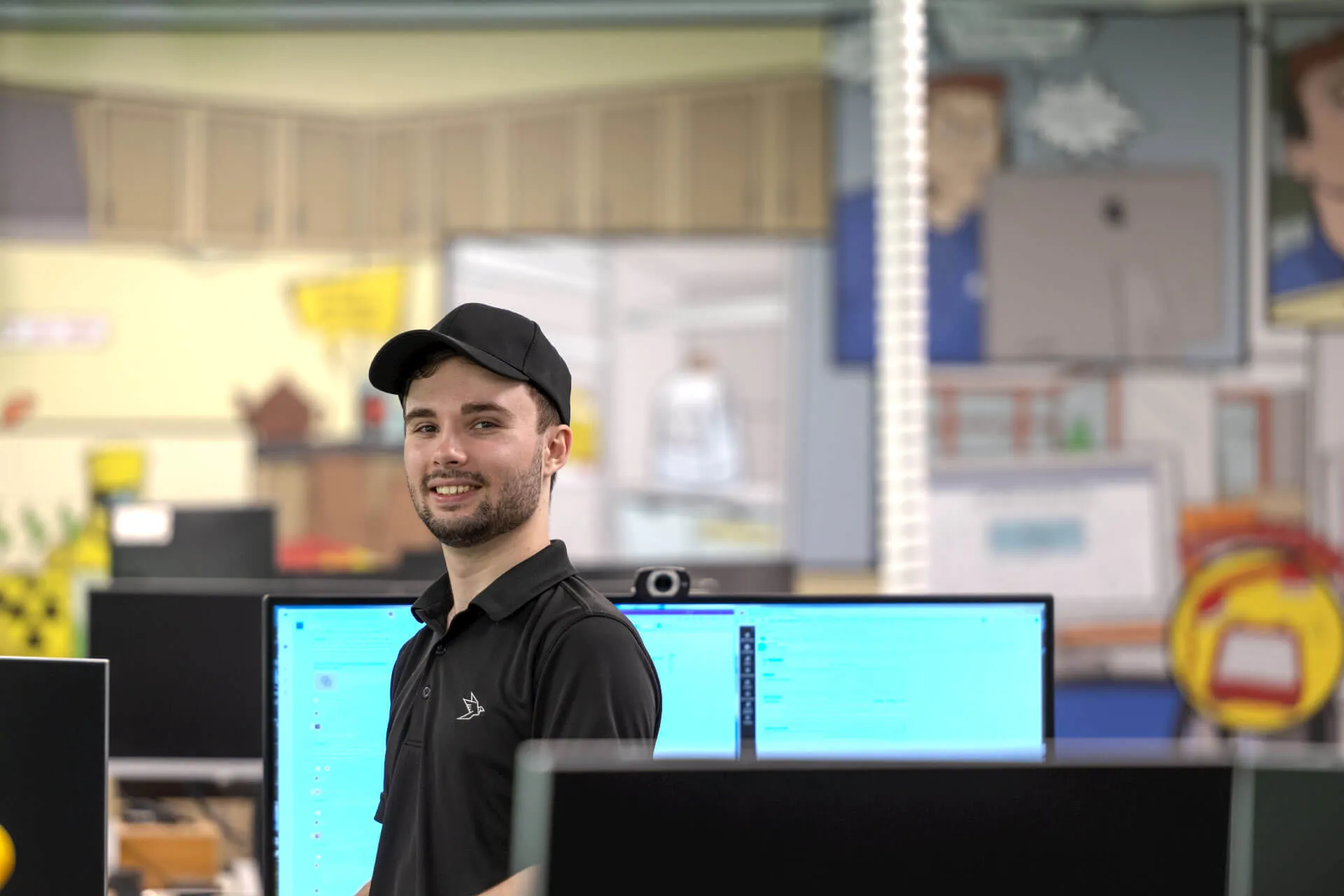 a man standing in front of two computer monitors