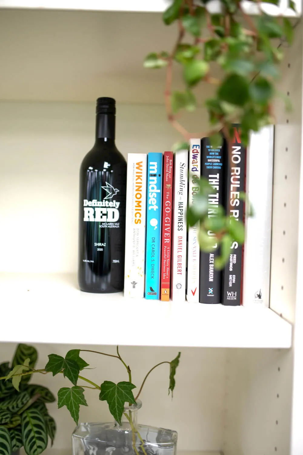 a bottle of wine sitting on top of a white shelf