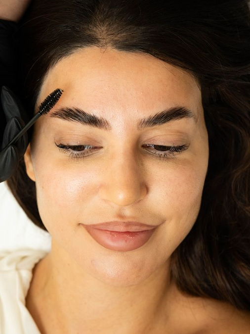 خبيرة تجميل تقوم بتمشيط شعيرات الحاجب للأعلى