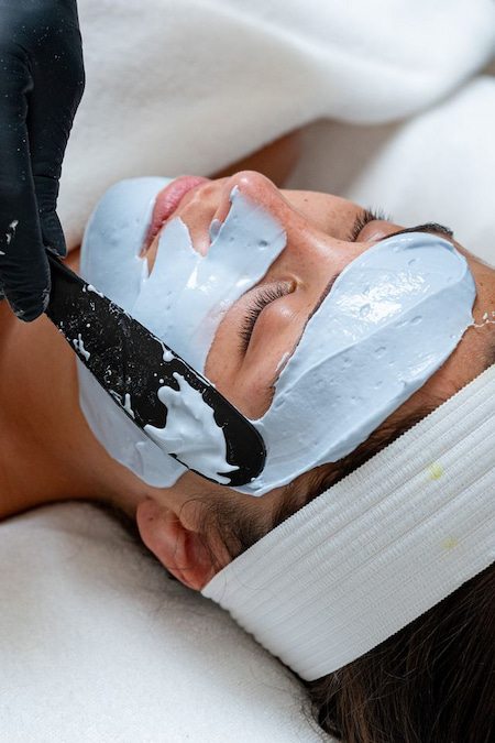 تطبيق القناع الأزرق على وجه مريضة باستخدام ملعقة مسطحة