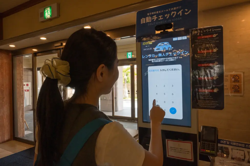 来店者がチェックイン機を操作してレンタカー受付を進める様子
