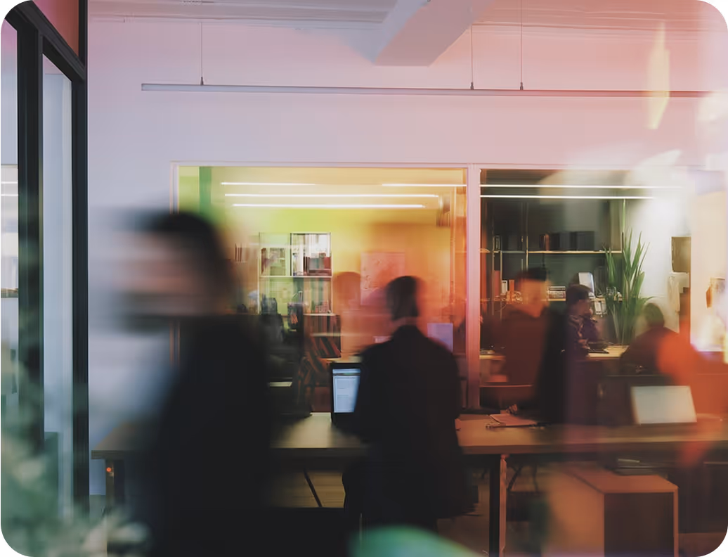 A blurred, dynamic view of a modern office space with people in motion, suggesting a busy environment.