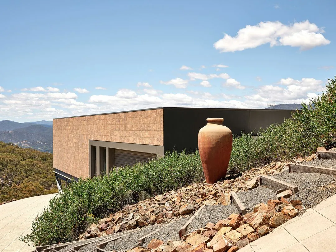 Modern hillside home with terracotta urn and mountain view