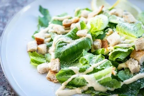 Klassisk Caesar-salat med romanosalat, krutonger, parmesan og kremet dressing – servert hos Riviera Restaurant i Oslo