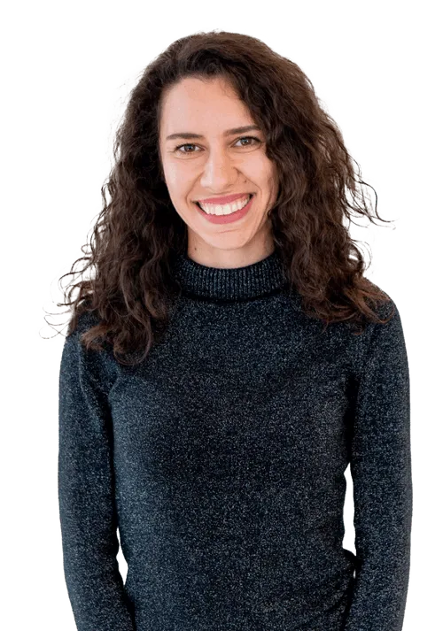 Frau mit lockigem Haar und dunklem Rollkragenpullover lächelt in die Kamera