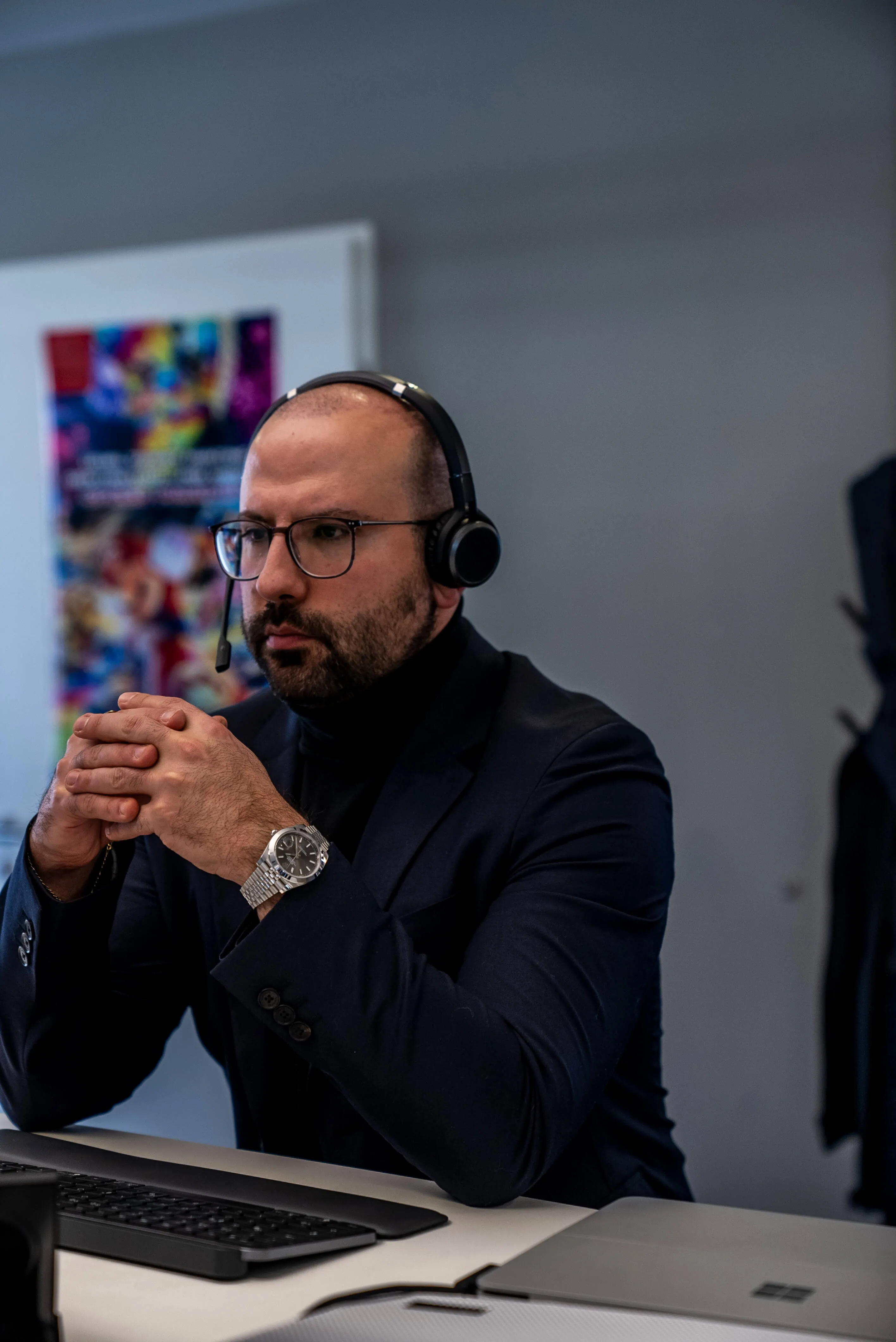 Mann mit Headset im Videocall am Schreibtisch