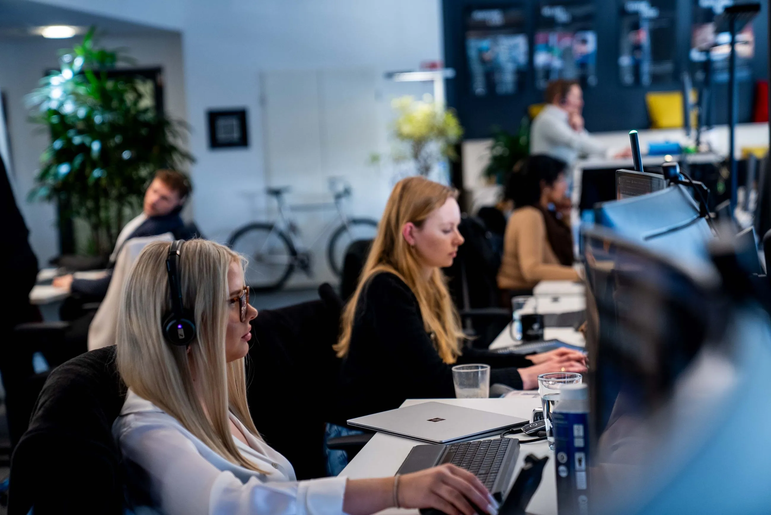 Mitarbeitende arbeiten konzentriert im Großraumbüro