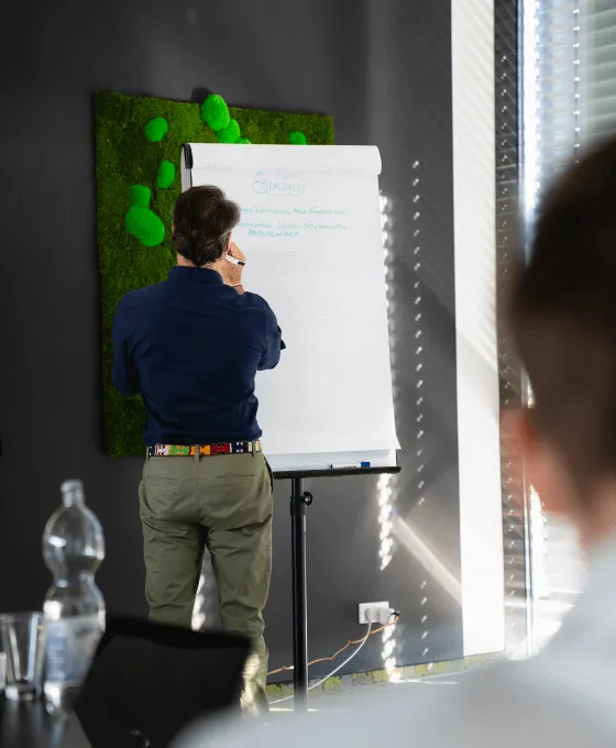 Mann steht vor Flipchart in einem Raum