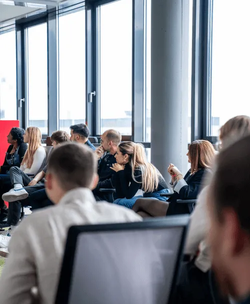 Mitarbeiter sitzen in einem modernen  Konferenzraum und hören einem Vortrag aufmerksam zu