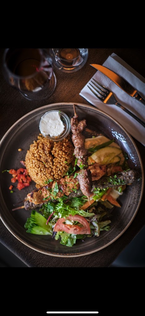 Grillspyd med okse og kylling servert med bulgur, frisk salat, hvit saus og grillede grønnsaker – Midtøsten-inspirert hovedrett