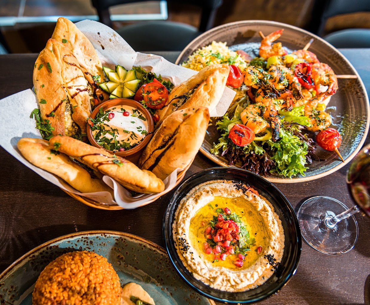 Midtøsten mezze med hummus, libanesisk brød, grillet scampi og grønnsaker – servert med friske urter og granateple
