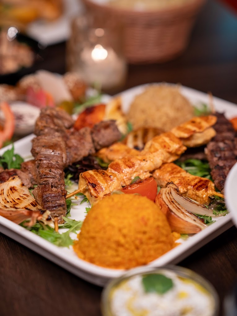 Koskos Mix Grill med kyllingspyd, lammespyd og oksekjøtt, servert med bulgur, ris og grillede grønnsaker.
