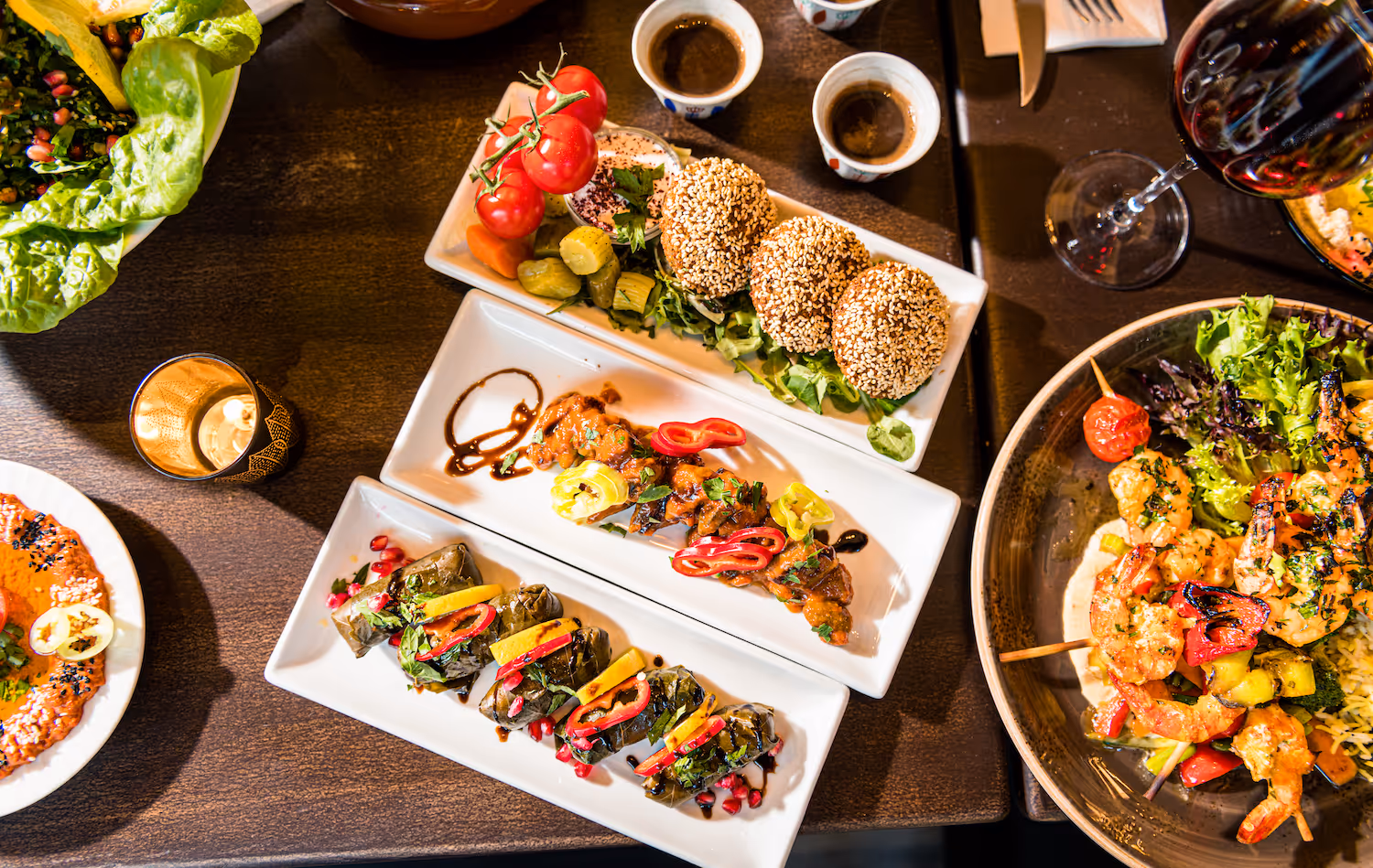 Tradisjonelle meze-retter hos KosKos Restaurant: grillspyd med paprika, vinblader fylt med ris og urter, falafel med sesam, og småretter servert med arabisk kaffe og rødvin.
