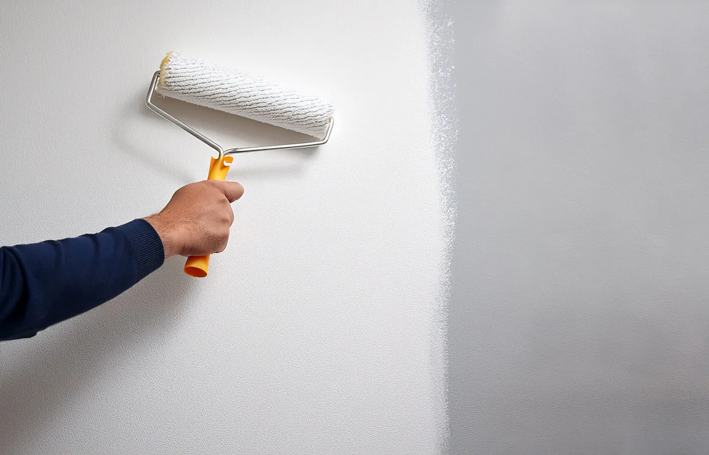 Person, die eine Wand streicht