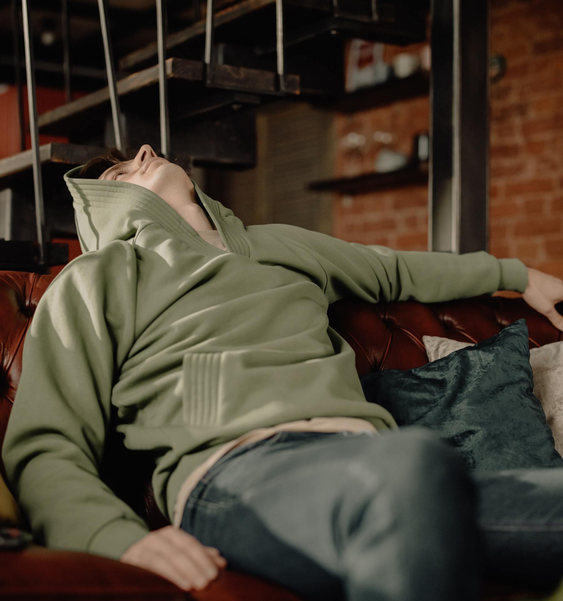 Man leaning backwards on a couch, staring up