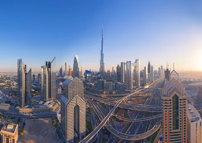 Panoramic view of Dubai skyline with Burj Khalifa and modern skyscrapers at sunrise.
