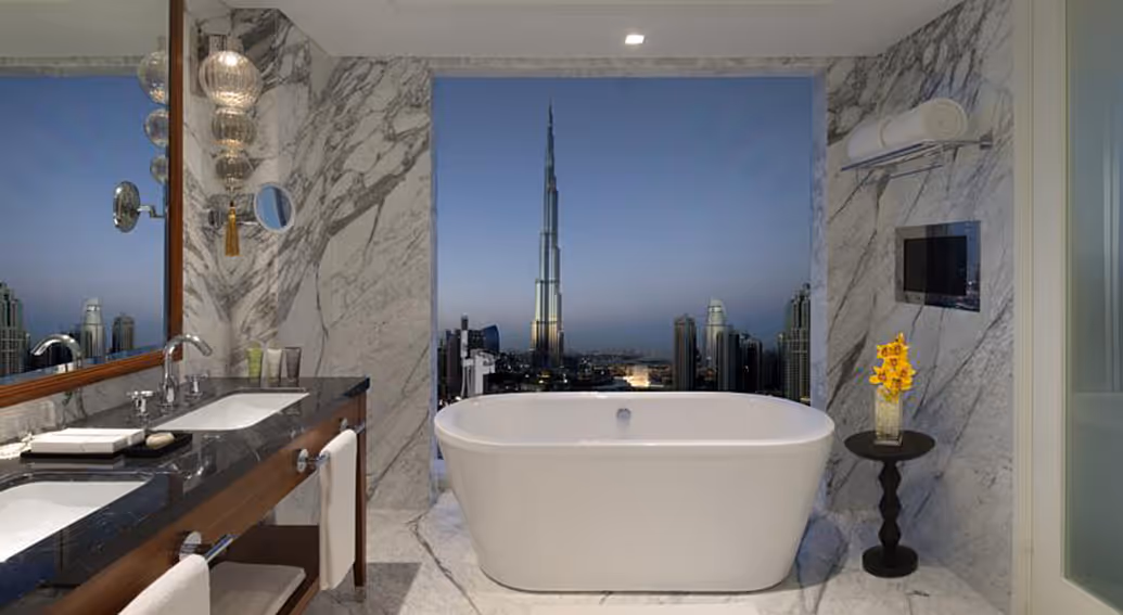 Luxury marble bathroom in Dubai with freestanding bathtub and Burj Khalifa view.