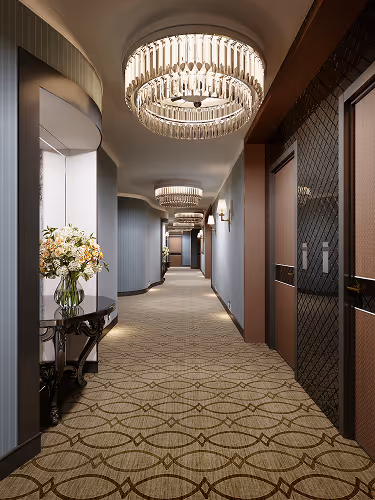 Elegant hotel hallway with patterned carpet flooring, luxury chandeliers, and floral decor, highlighting professional carpet cleaning and maintenance.