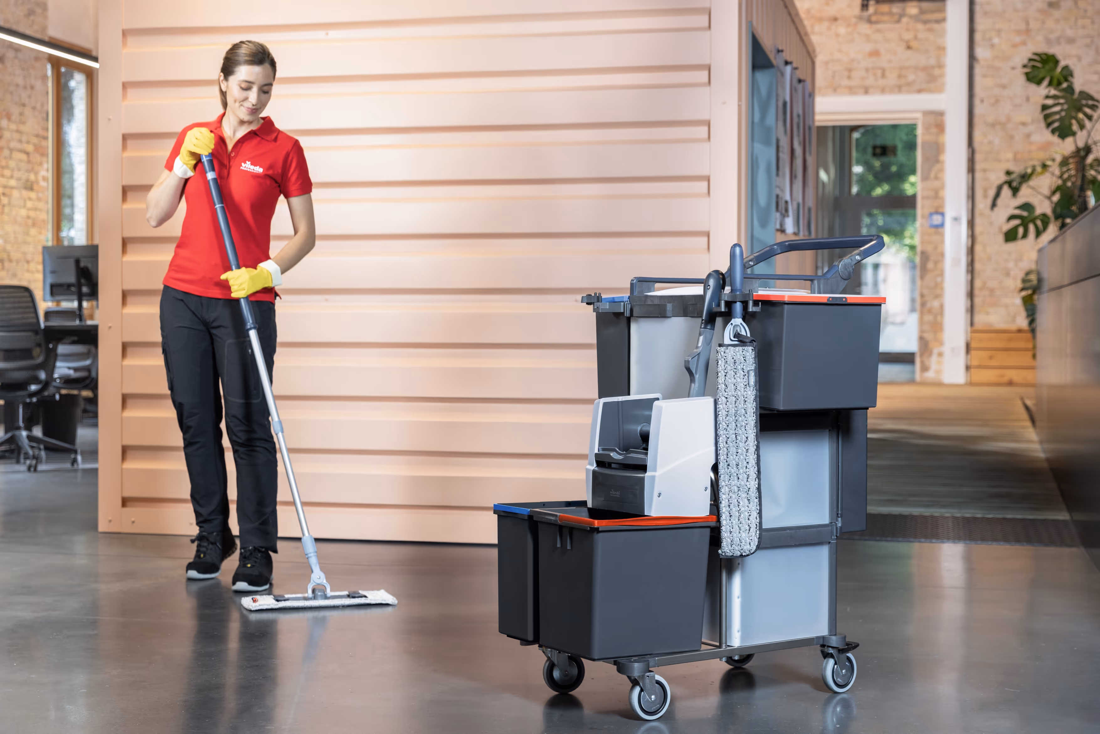 Professional office cleaner mopping floor with modern cleaning trolley and equipment for spotless commercial hygiene.