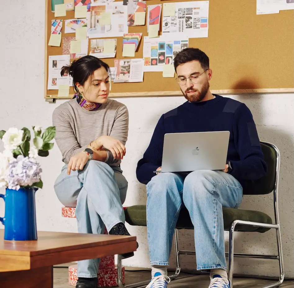 un homme et une femme qui travaillent avec un ordinateur dans un bureau
