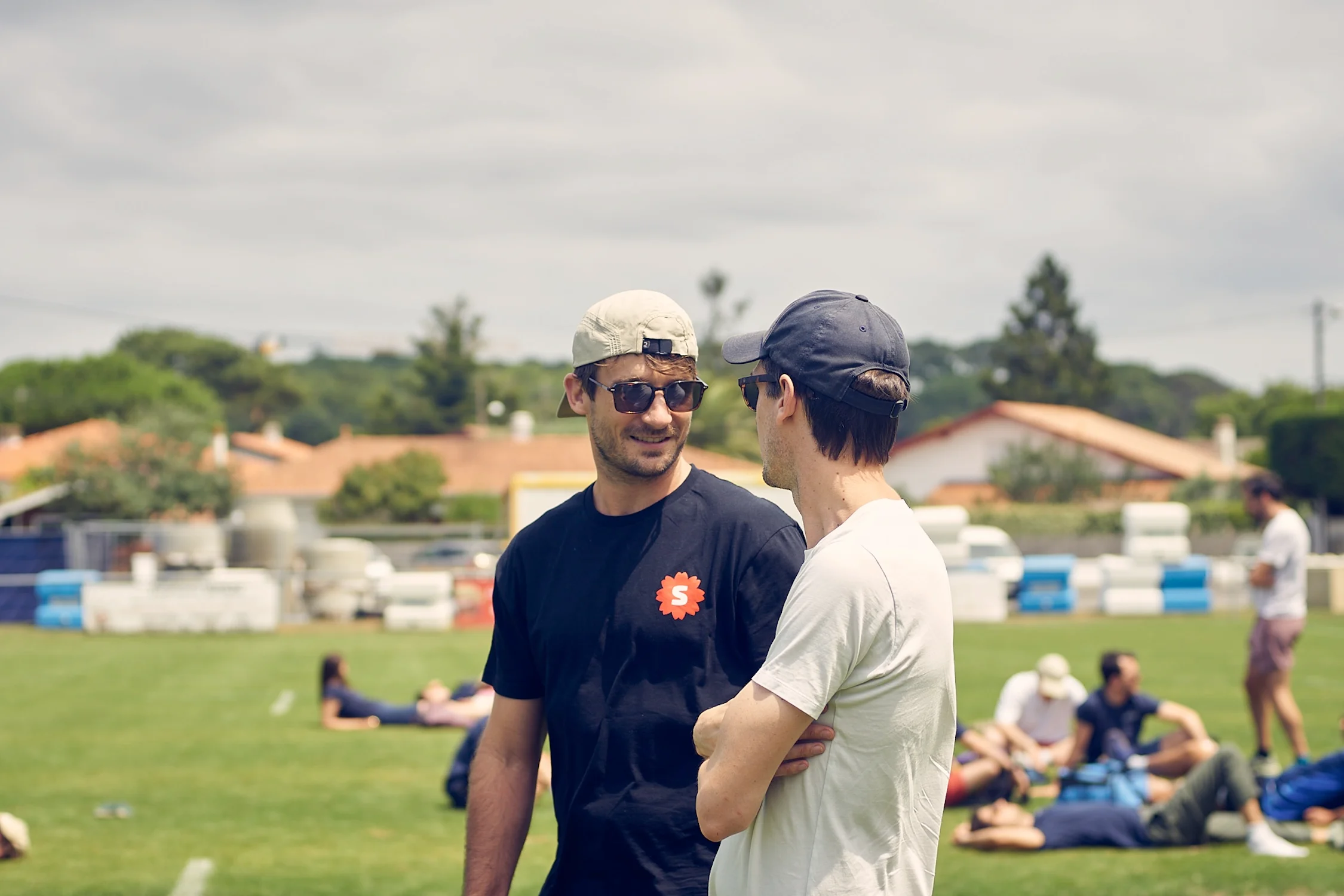 Deux membres de l'équipe Work With Island discutant sur un terrain lors du séminaire d'été à Biarritz