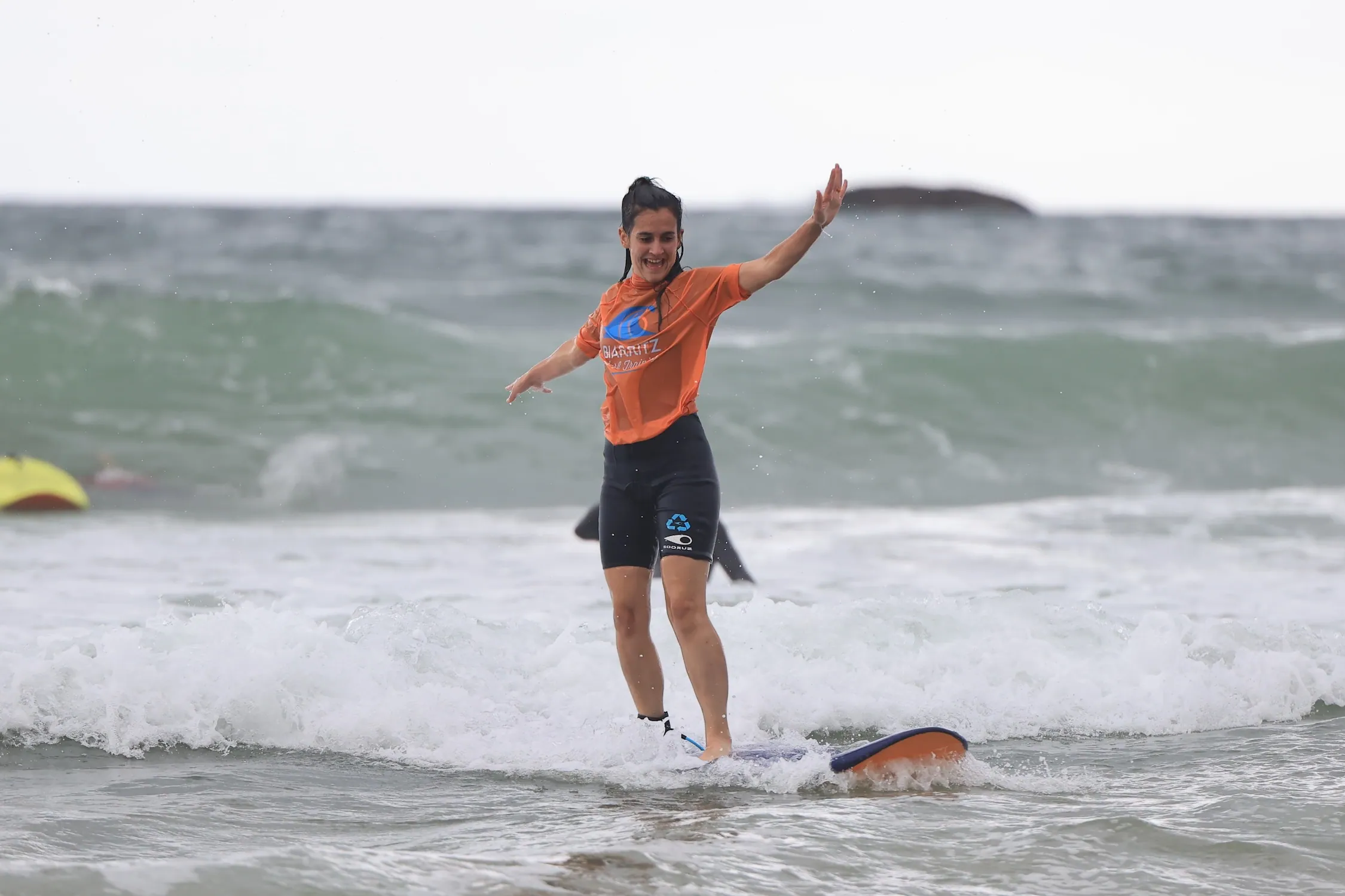 Membre de l'équipe Work With Island en équilibre sur une planche de surf lors d'un cours à Biarritz