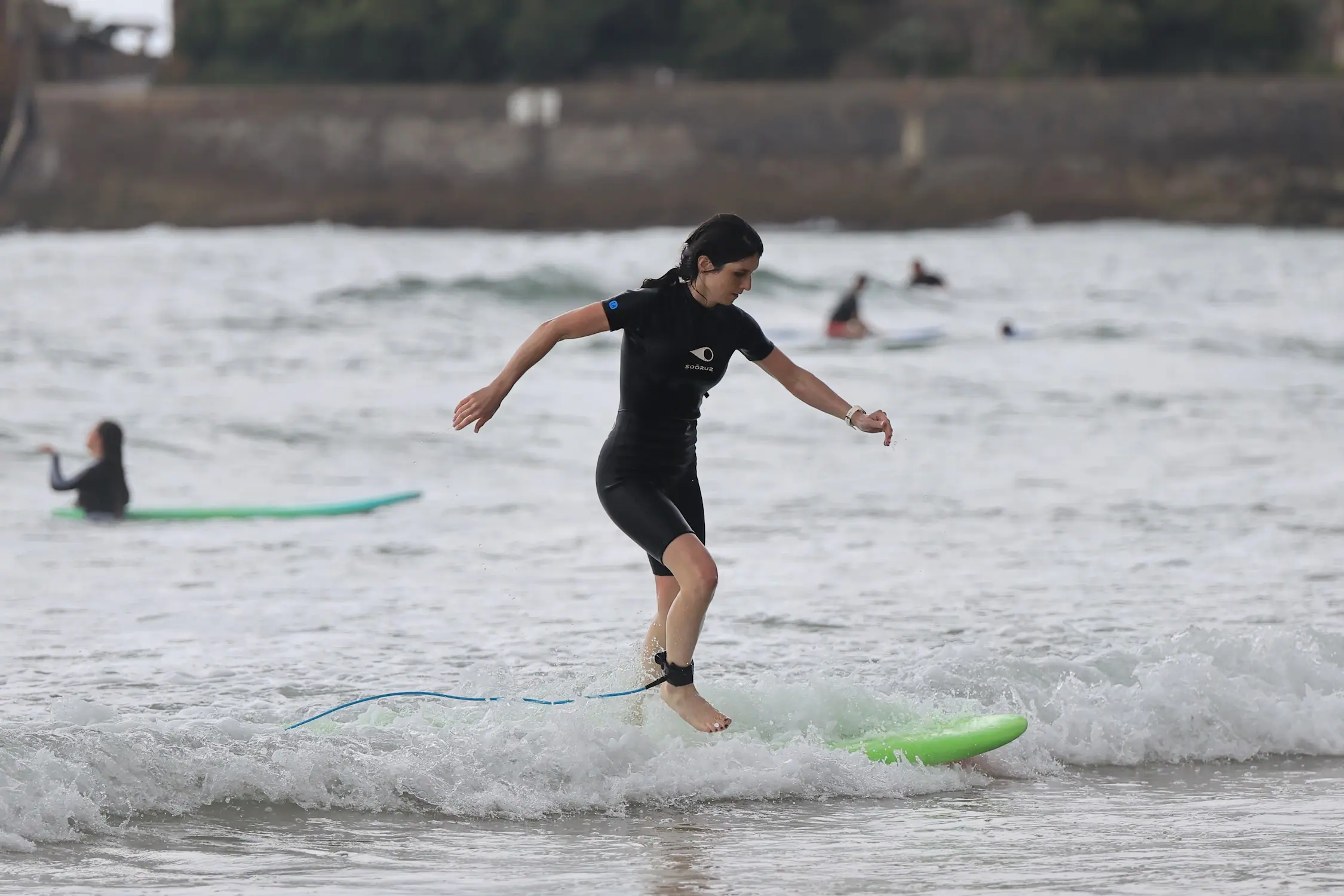 Membre de l'équipe Work With Island en équilibre sur une planche de surf lors d'un cours à Biarritz