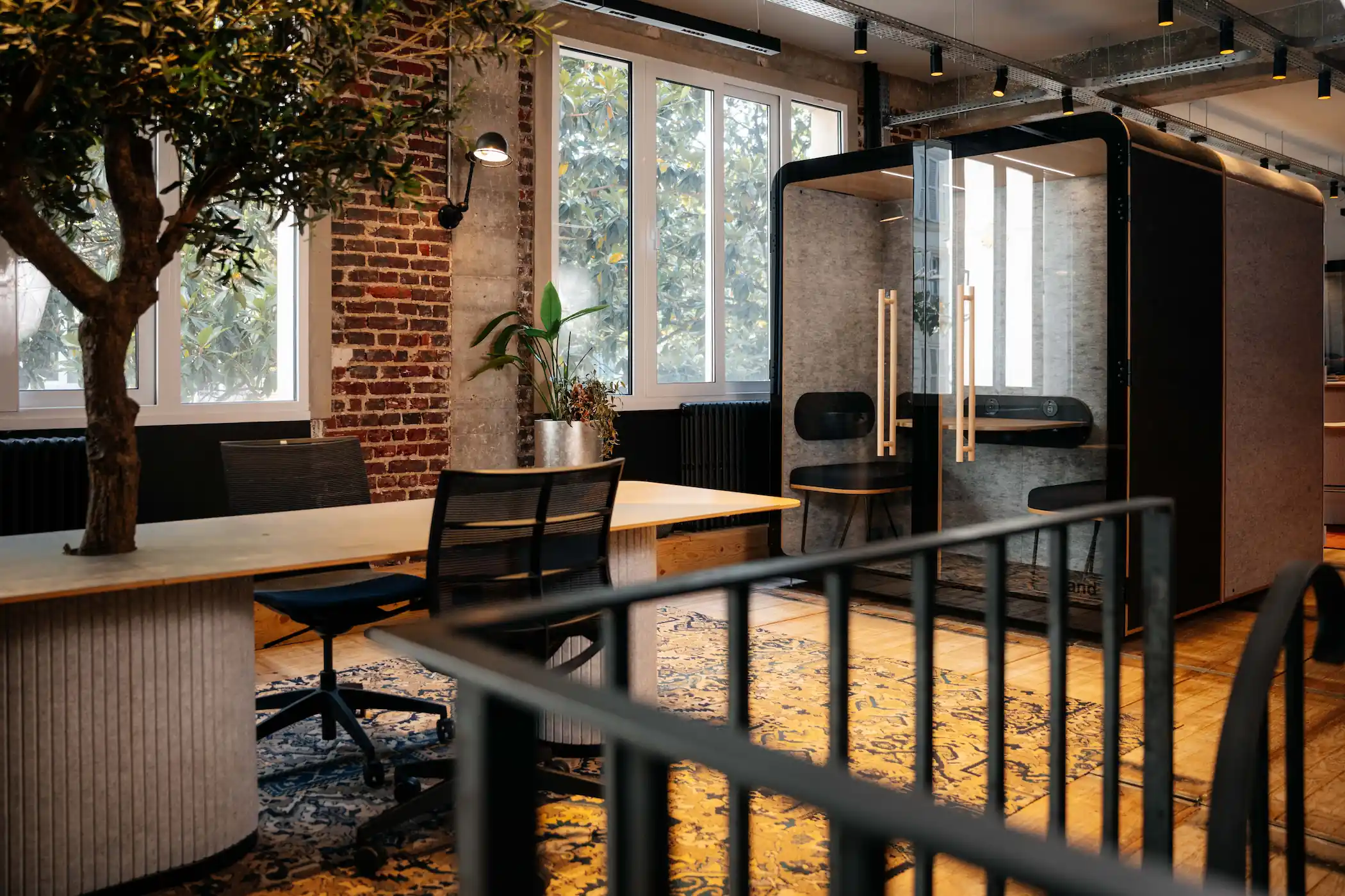 Cabines acoustiques Island Duo vides dans un espace de travail au décor industriel avec mur de briques