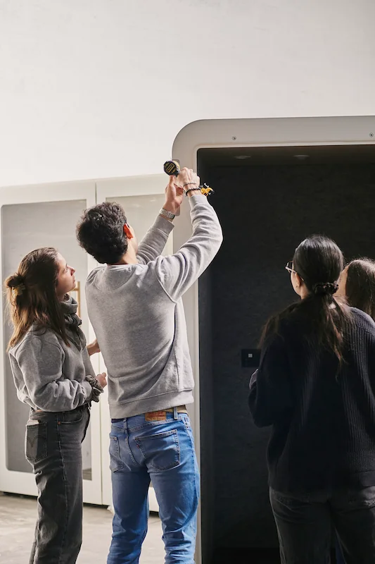 Membres de l'équipe Work With Island installant l'éclairage intérieur d'une cabine acoustique au Fablab