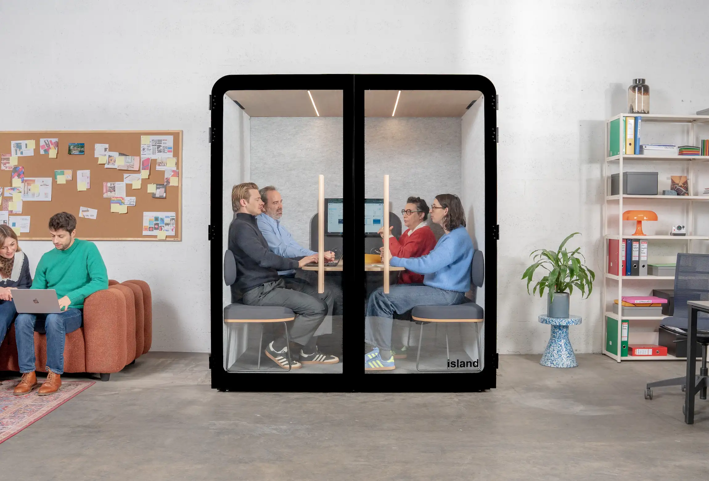 Cabine acoustique Island Quattro Light noire avec quatre binômes de collaborateurs en réunion côte à côte