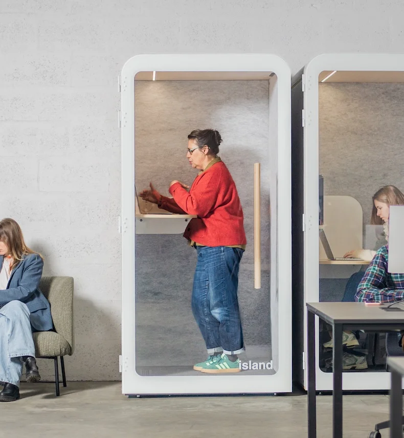 Personne debout dans une cabine acoustique individuelle island solo