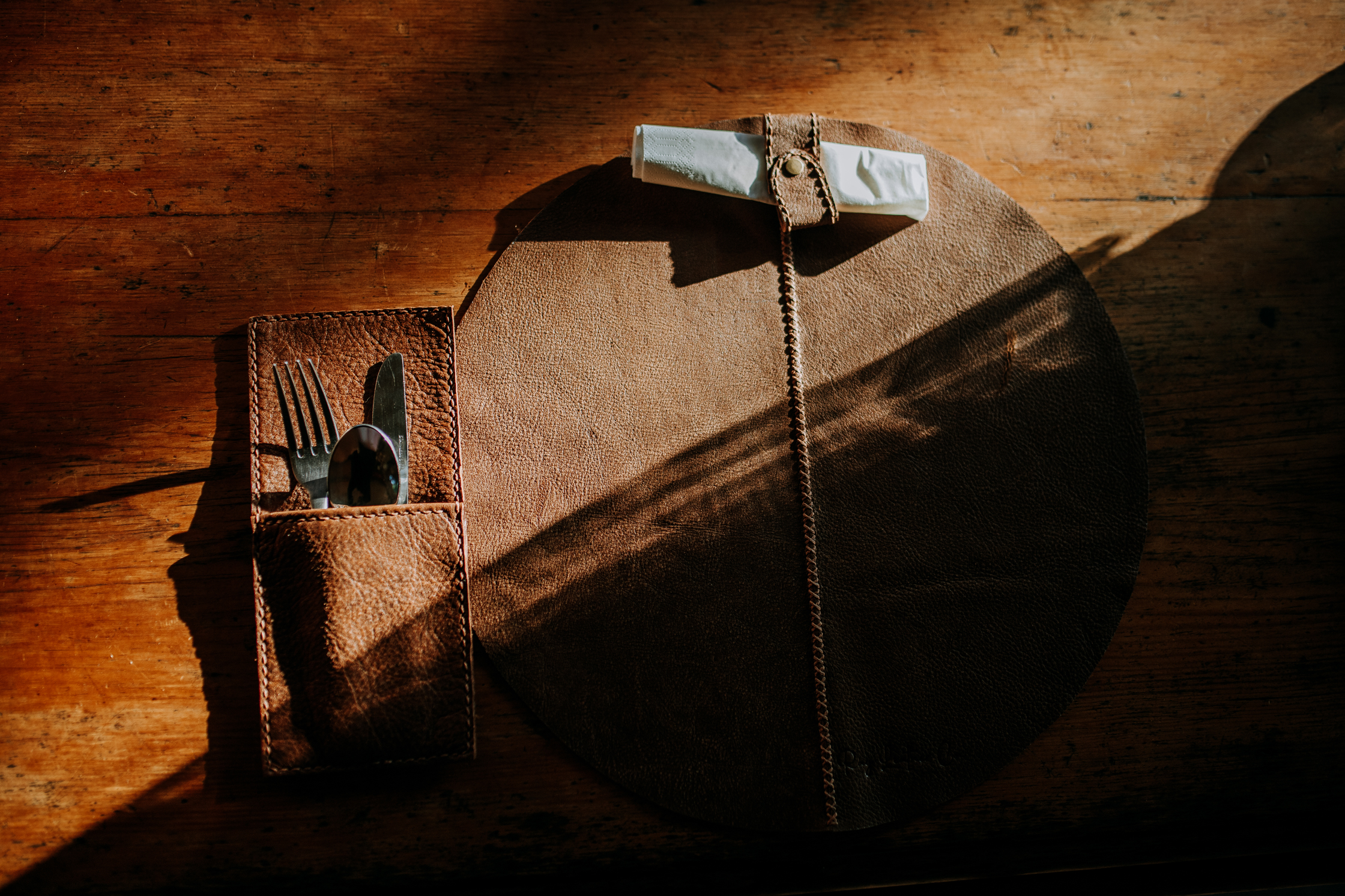 Handmade leather placemats on a country dining table