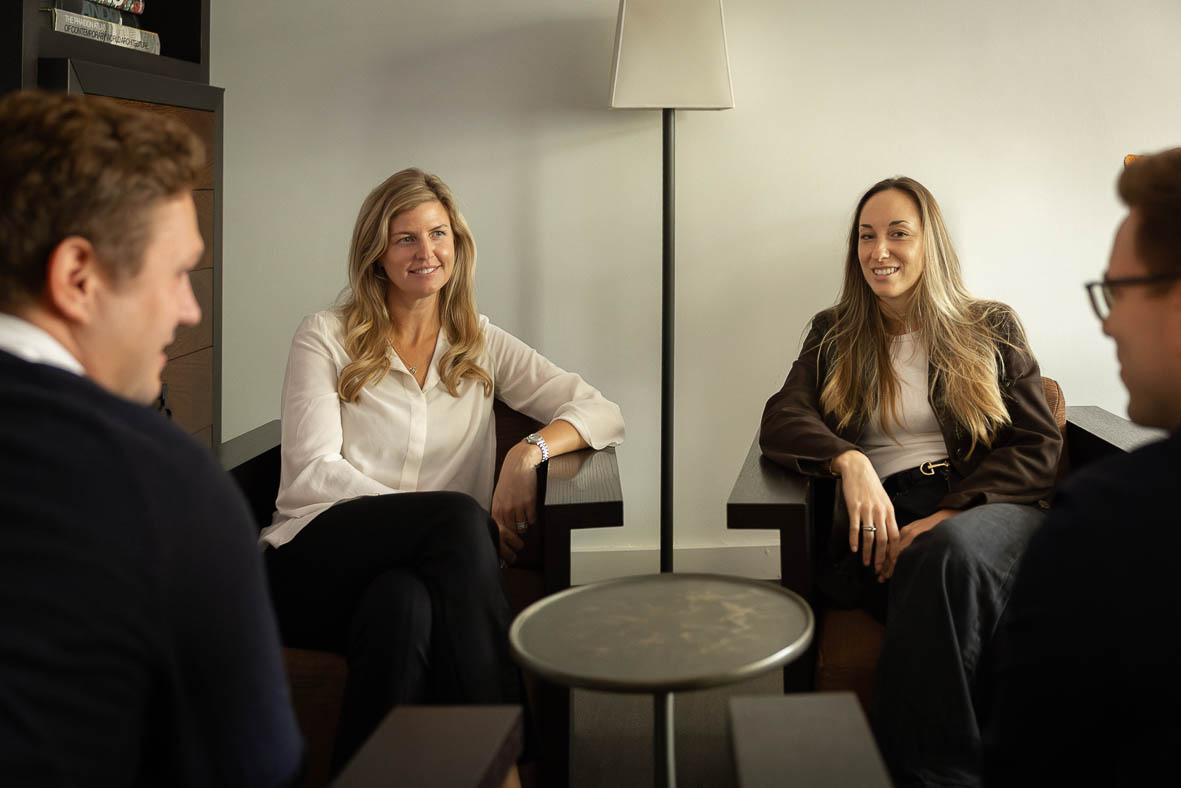 A team of people sitting in chairs smiling