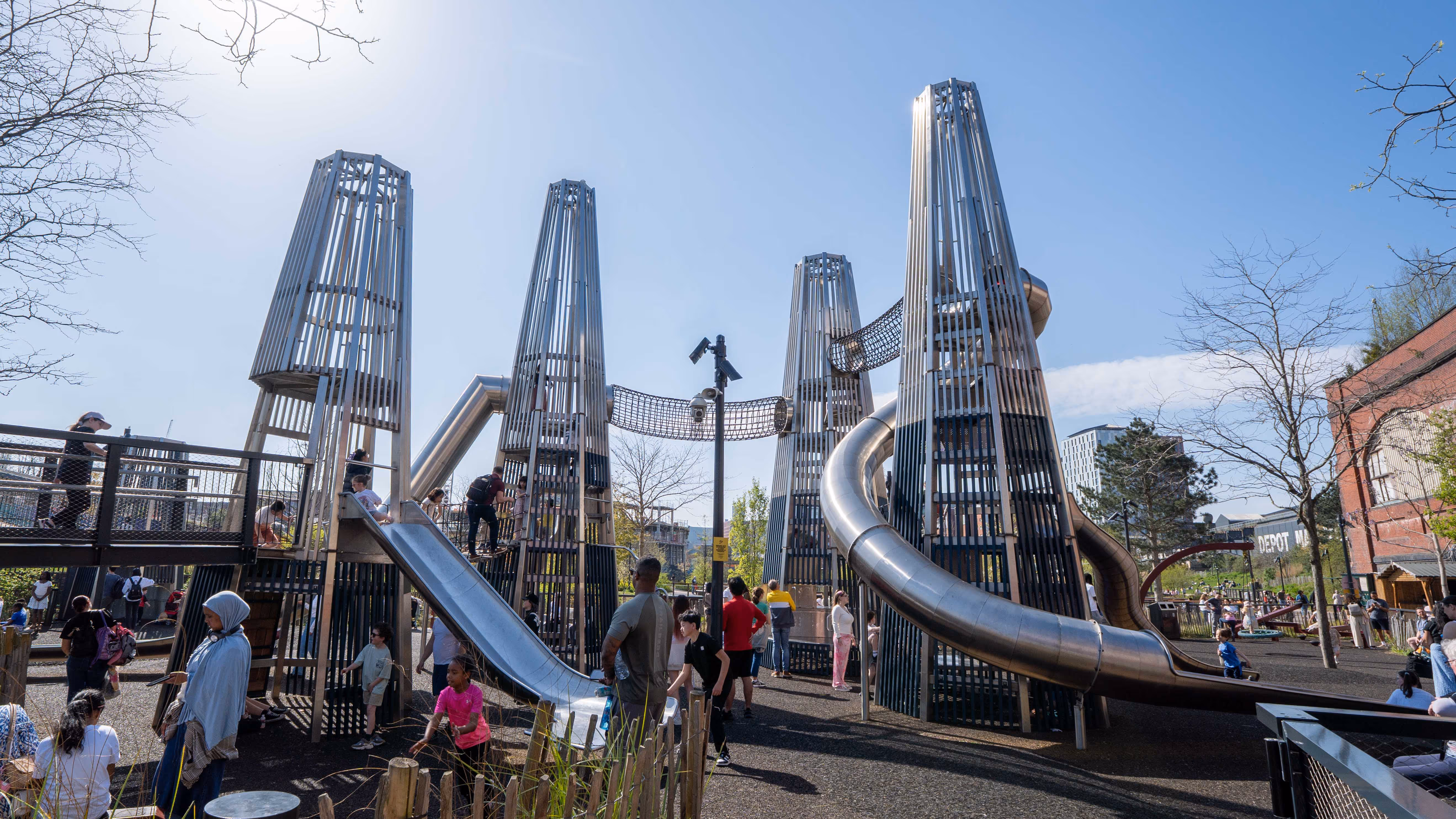 Wide view of completed bespoke playground space showing towers, bridges and climbing structures