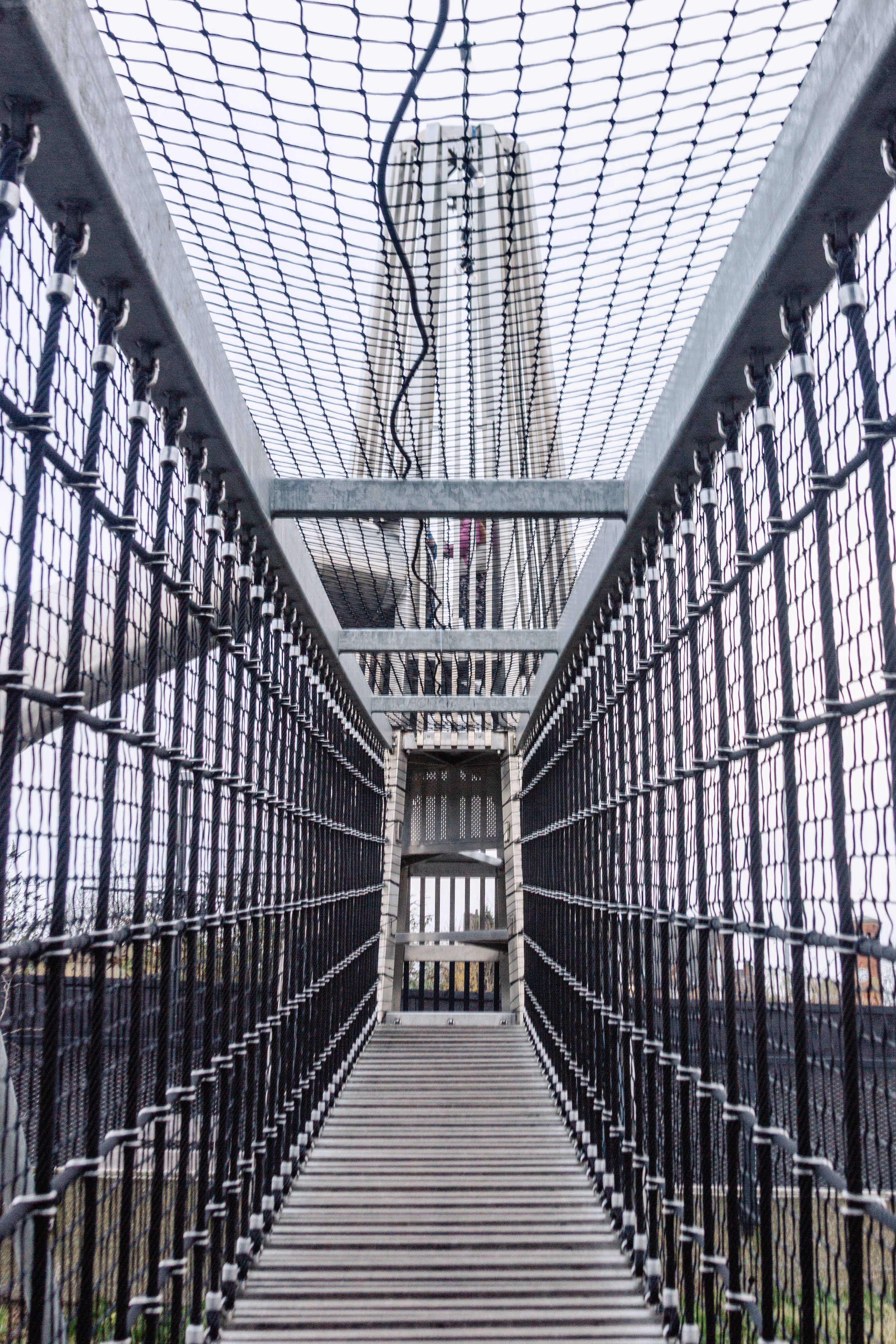 Rope suspension bridge crossing over river as part of bespoke playground adventure route