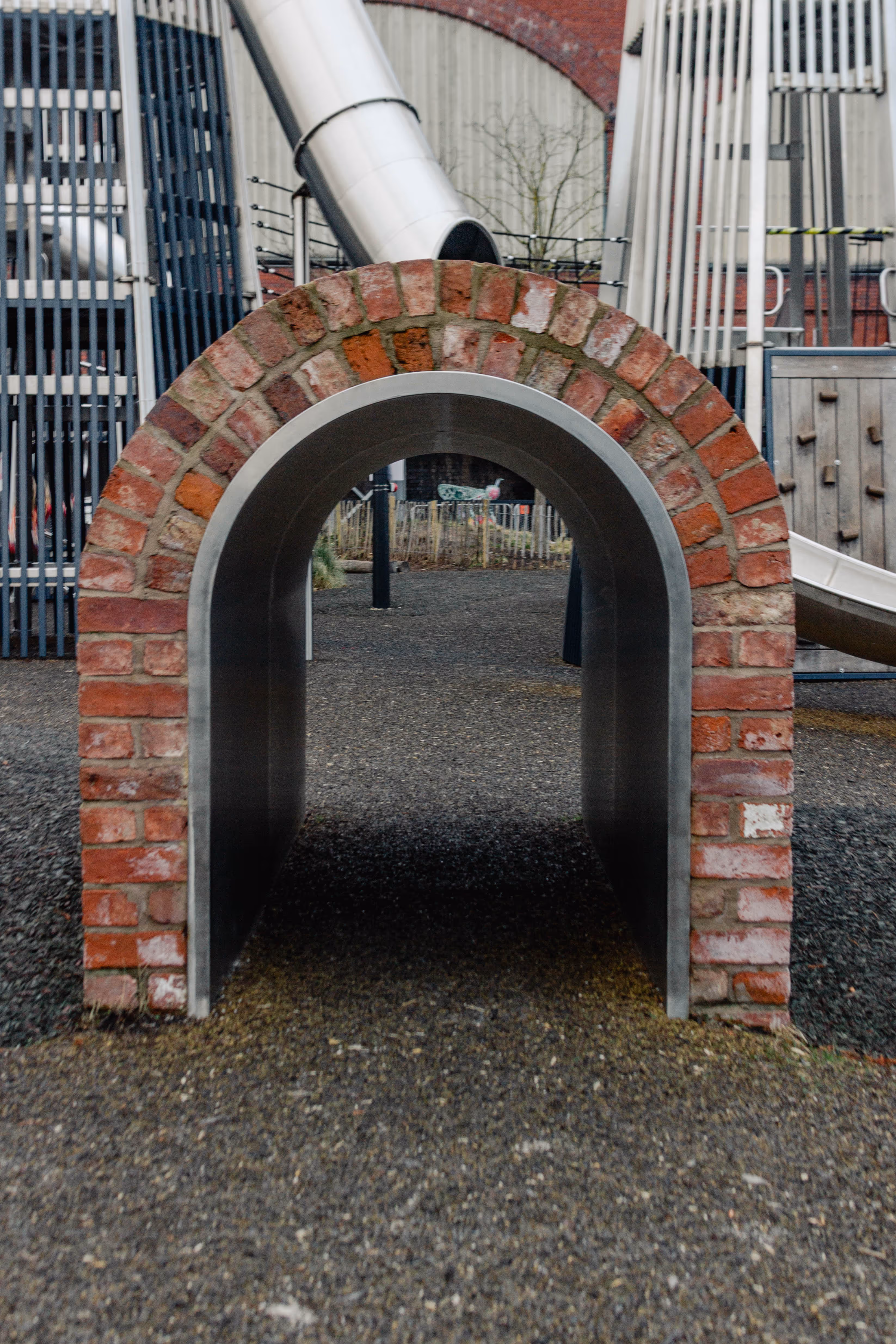 Brick arch tunnel integrated into bespoke playground design creating themed play passage