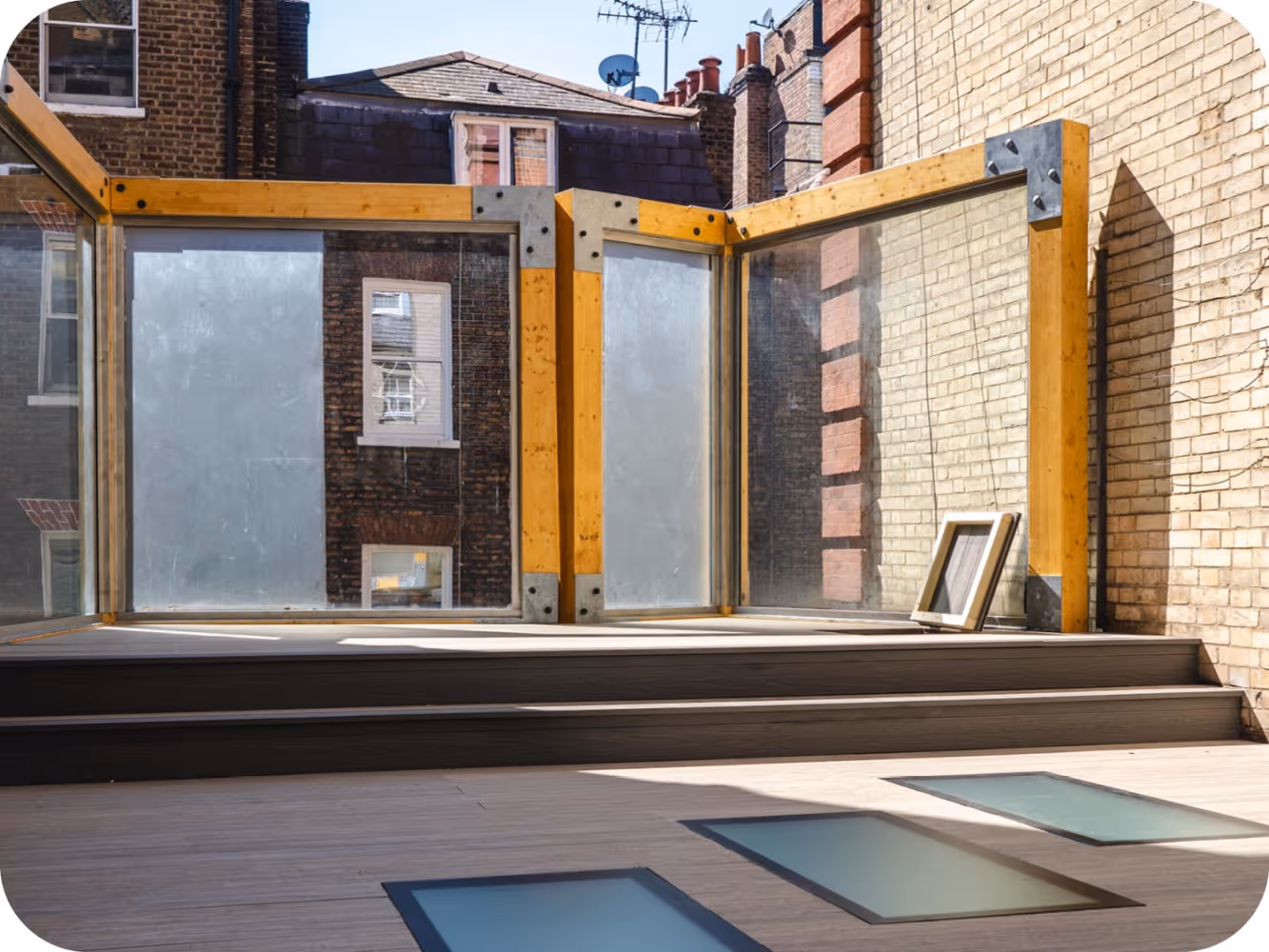 Timber cube play structures installed in a Soho school playground with composite decking, walk-on glass and climbing ropes