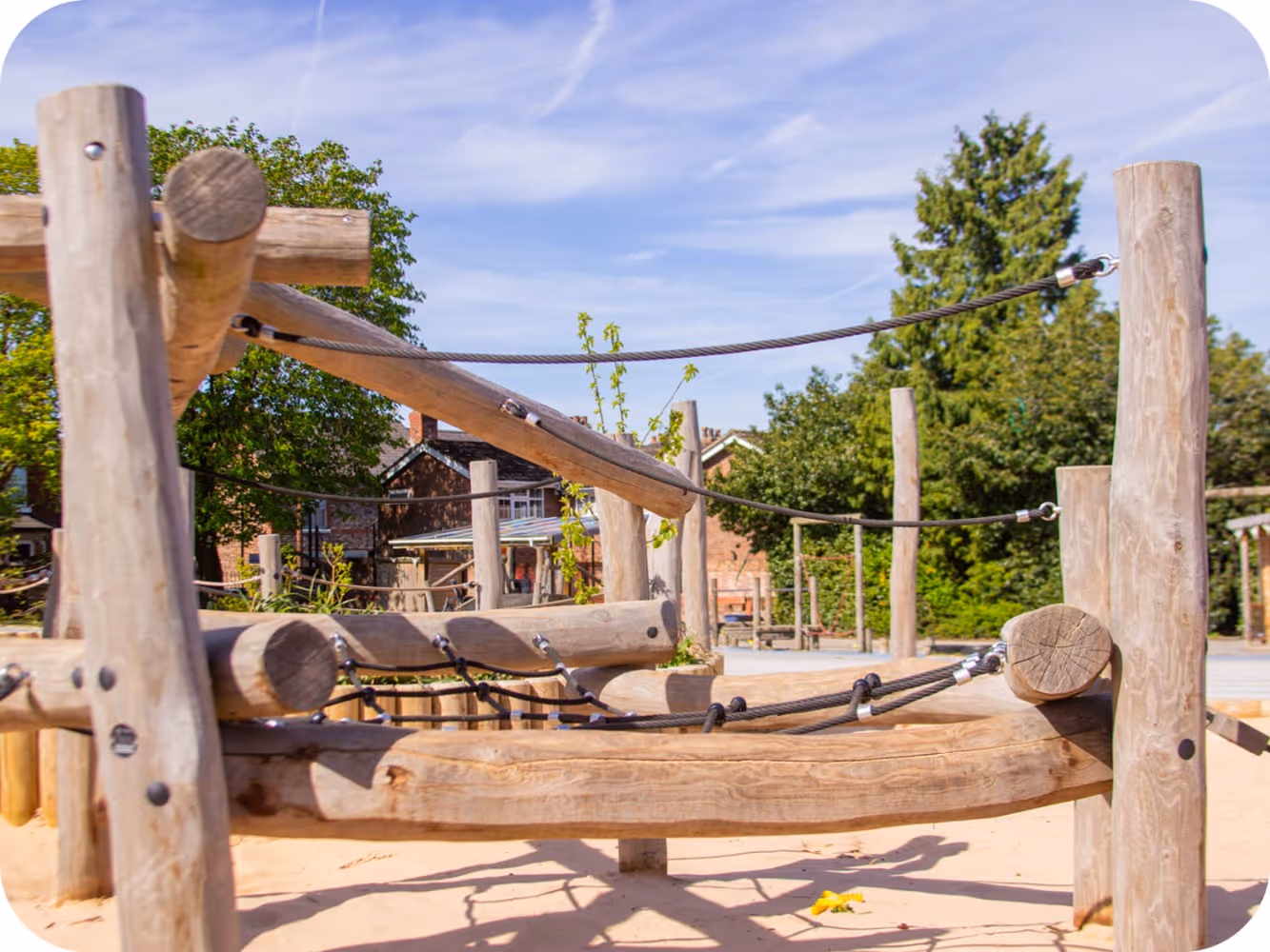 Close-up of Robinia timber playground equipment with rope climbing nets, stainless steel fixings and sand play surfacing