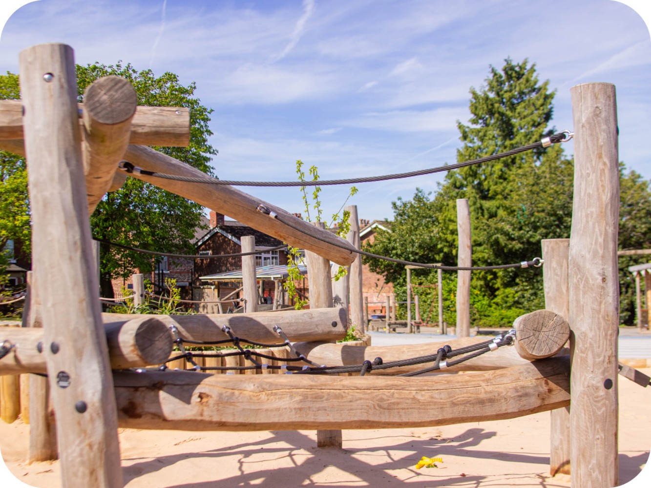 Close-up of Robinia timber playground equipment with rope climbing nets, stainless steel fixings and sand play surfacing