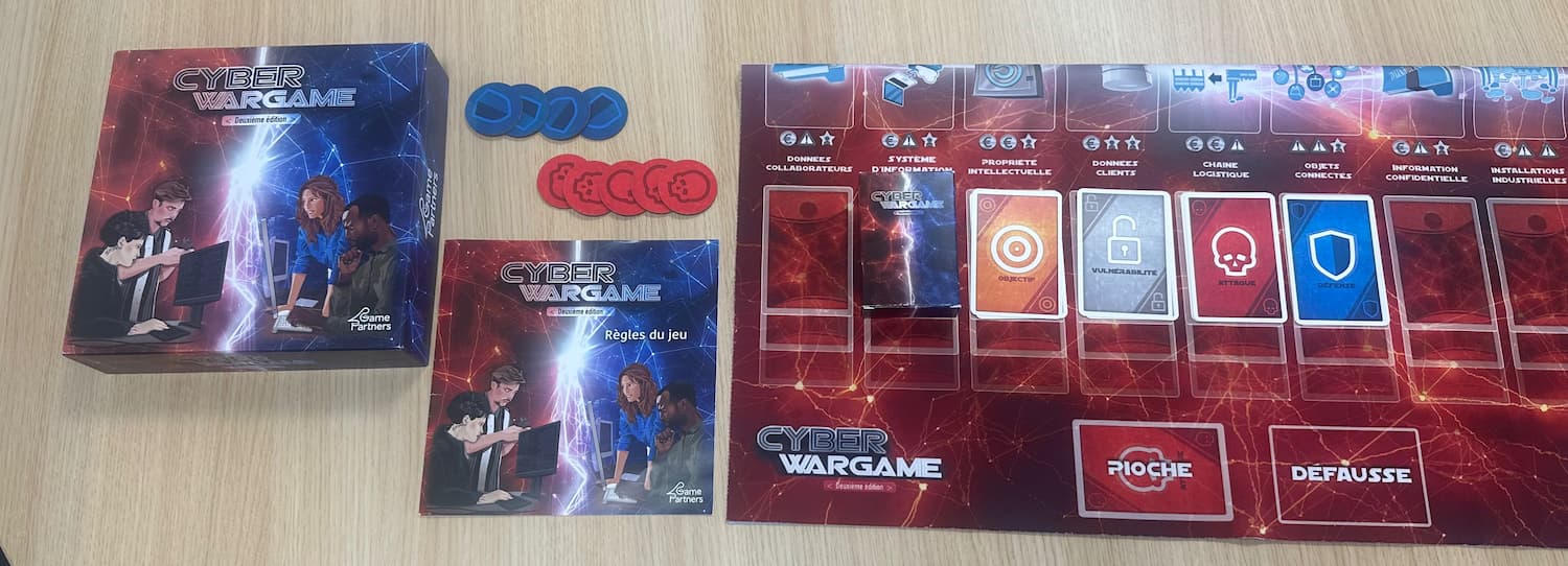 Image présentant la boîte et le plateau du jeu Cyber Wargame – deuxième édition, serious game immersif dédié à la sensibilisation et à la formation en cybersécurité.