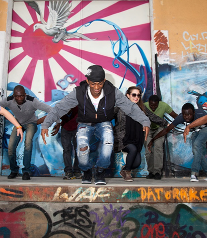 Eine gruppe von jungen Männern auf einer Bühne mit Graffiti gestaltet bei einer Tanzaufführung