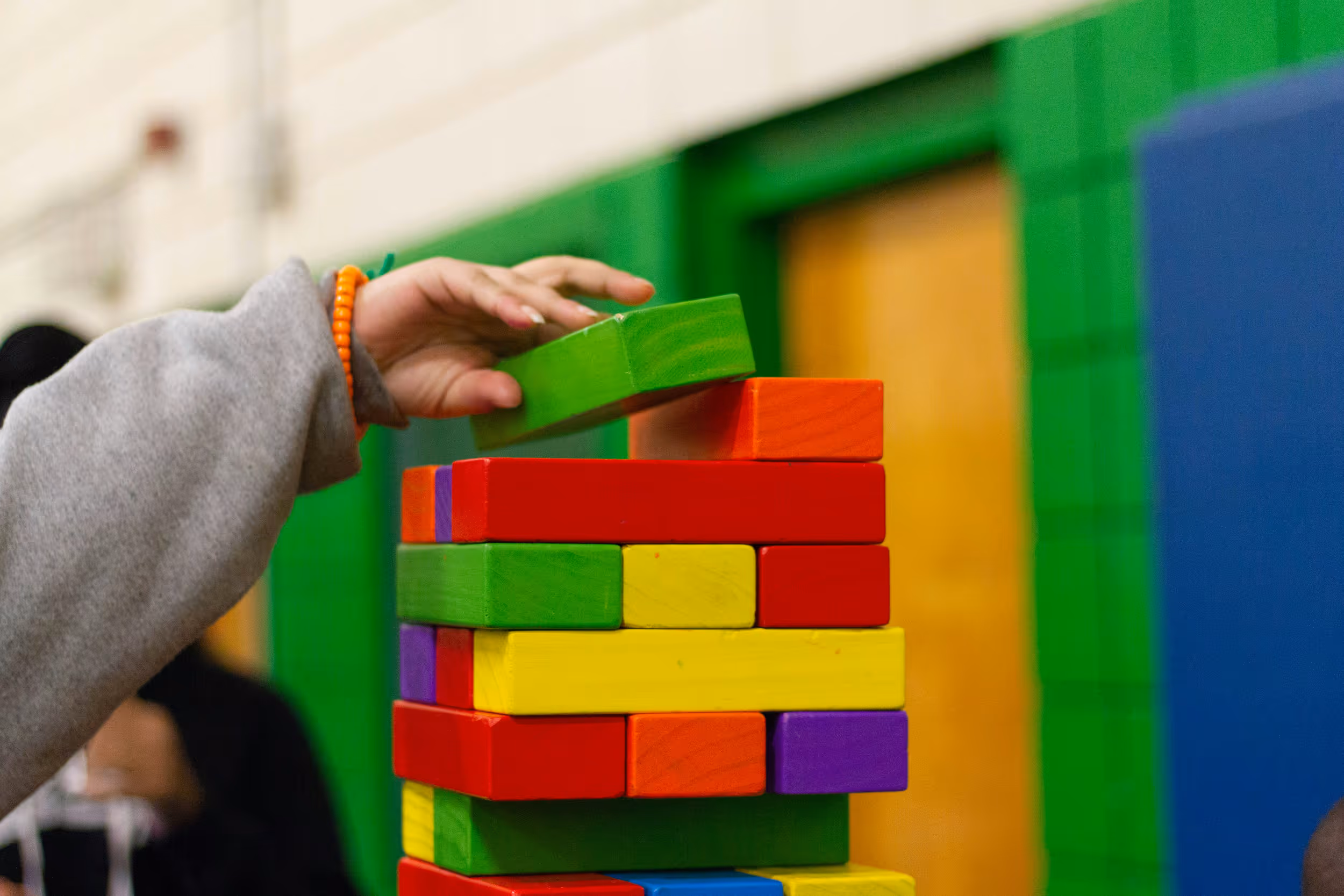Child using building blocks to create tower