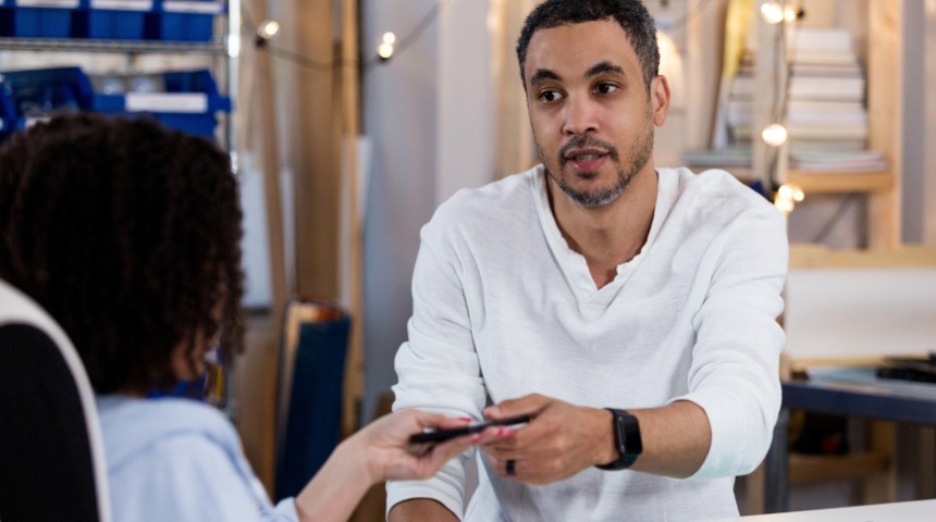 Übergabe eines deviceplus Smartphones an einen Mitarbeiter.