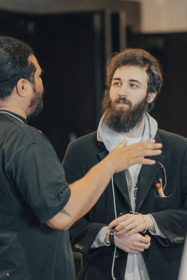 Two professionals in conversation, one gesturing while speaking